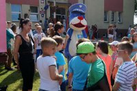 Policjantka wygłasza pogadankę. Sznupek bawi się z dziećmi.