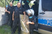 Dzieci oglądają policyjny sprzęt i radiowóz.