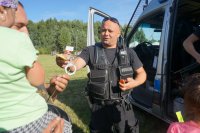Policjant wręcza dzieciom odblaski.