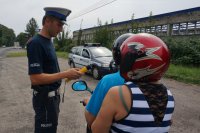Policjant sprawdza trzeźwość motorowerzysty.