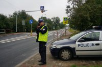 Policjant z miernikiem prędkości przy przejściu dla pieszych przy szkole.