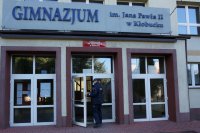 Policjant wchodzi do budynku gimnazjum.