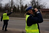 Policjantka patrzy przez lornetkę.