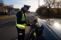 Policjant sprawdza stan trzeźwości kierującego pojazdem.