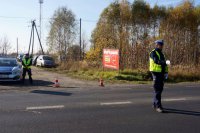 Policjant kieruje ruchem przy cmentarzu.