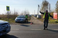 Policjant kieruje ruchem przy cmentarzu.