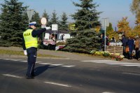 Policjant kieruje ruchem przy cmentarzu.