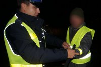 Policjant wręcza pieszemu odblaski.