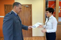 Komendant wręcza nagrodę.