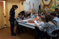 Policjantka tłumaczy dzieciom zasady konkursu.
