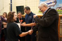 Dyrektor szkoły wręcza medal Karolinie Król.