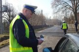 Policjant kontroluje stan trzeźwości kierującego.