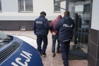 Policjanci prowadzą zatrzymanego.