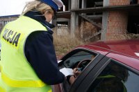 Policjantka kontroluje samochód.
