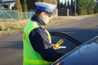 Policjant kontroluje samochód.