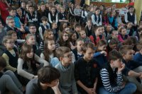 Uczniowie Szkoły Podstawowej nr 1 w Kłobucku słuchają pogadanki policjanta.