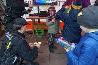 Policjant wręcza dzieciom odblaski.