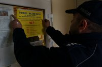 dzielnicowy rozkleja plakaty