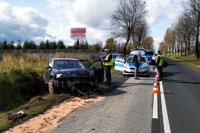 policjant stoi przy rozbitym samochodzie audi