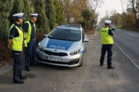 policjanci prowadzą stoją przy radiowozie i prowadzą działania prędkość, mierzą prędkość i kontrolują auta