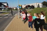 policjanci znajdujący się przed przejściem dla pieszych tłumaczą najmłodszym uczniom zasady bezpiecznego przechodzenia przez jezdnię