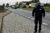 policjant ruchu drogowego a w tle droga krajowa numer 43, radiowóz i ciągniki rolnicze