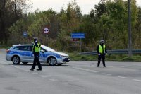 policjanci kierują ruchem drogowym, w tle radiowóz