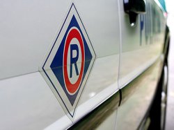 Litera R symbol ruchu drogowego, na drzwiach radiowozu.
