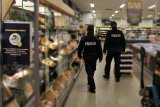 umundurowani policjanci kontrolują placówki handlowe