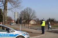 pieszy przechodzący przez pasy i policjant mierzący prędkość