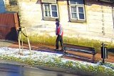 Sylwetka idącego mężczyzny w czerwono szarej kurtce