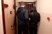 policjant kryminalny prowadzący zatrzymanego mężczyznę