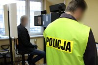 technik kryminalistyki podczas wykonywania czynności z podejrzanym
