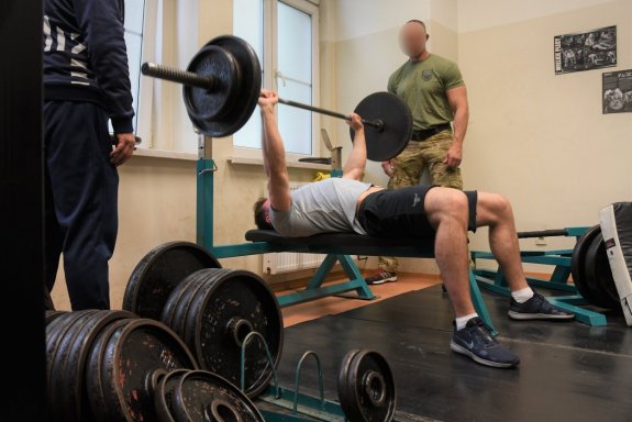 mężczyzna na ławce podnoszący ciężary