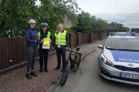 policjantka ruchu drogowego, pracownik urzędu gminy i i rowerzystka trzymająca odblask