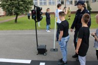 policjantka prowadzi praktyczne działania na mobilnym miasteczku ruchu drogowego