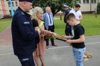 umundurowany policjant i kobieta rozdają odblaski