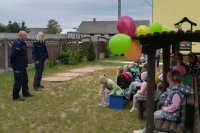 policjanci rozmawiaja z dziećmi, które na zdjęciu siedzą po lewej stronie