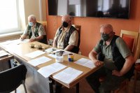 na zdjęciu widać trzech przedstawicieli Państwowej Straży Rybackiej, którzy siedzą na krzesełkach za stołem, przodem do zdjęcia