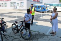 na zdjęciu widać chłopaka, który trzyma rower, za nim stoi umundurowany policjant a obok nauczycielka