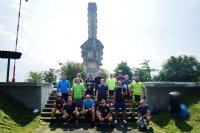 grupa mężczyzn w strojach sportowych w tle pomnik pod Mokrą