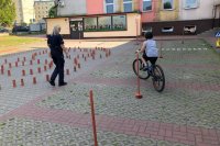 policjantka w mundurze i rowerzysta podczas praktycznego egzaminu na kartę rowerową