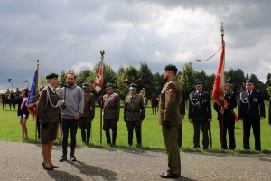 Składanie meldunku przez dowódcę uroczystości. W tle poczty sztandarowe