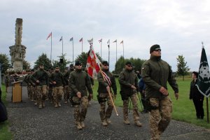 przemarsz wojska na tle pomnika