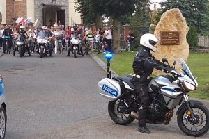 policjant na motocyklu, w tle rowerzyści