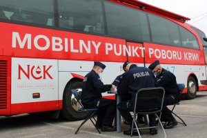 umundurowani policjanci przed mobilnym kriobusem