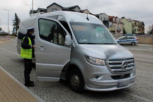 policjant rozmawia z pasażerką busa, która z niego wysiada