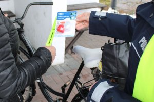 mundurowi przekazują odblaski rowerzystce
