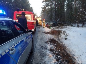granatowy samochód w rowie, obok policja i straż pożarna