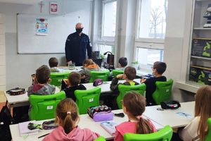 umundurowany policjant prowadzi prelekcje w klasie